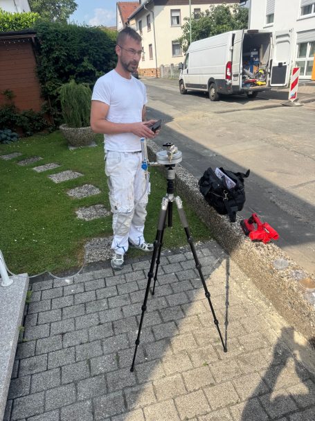Mitarbeiter bei der Entnahme einer Referenzprobe für eine Luftkeimmessung mit Petrischale.