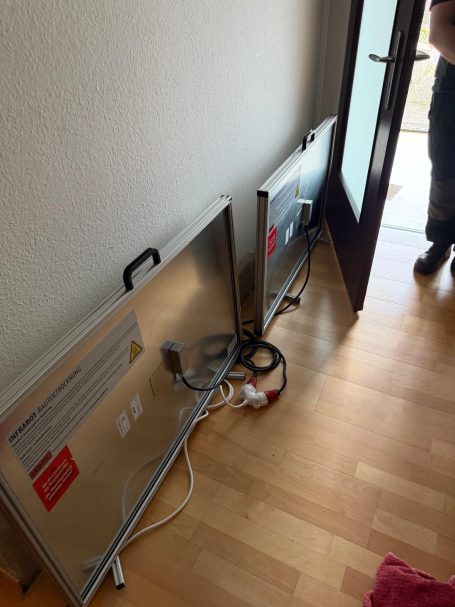 Technische Trocknung einer feuchten Wand mit Infrarot-Trocknungsplatten.
