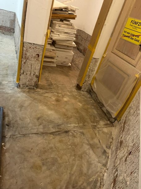 Kellerraum nach einem Rückstauschaden mit entferntem Estrich und abgeschlagenem Wandputz.