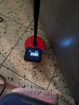 Messgerät bei der Feuchtemessung im Boden nach einem Wasserschaden.