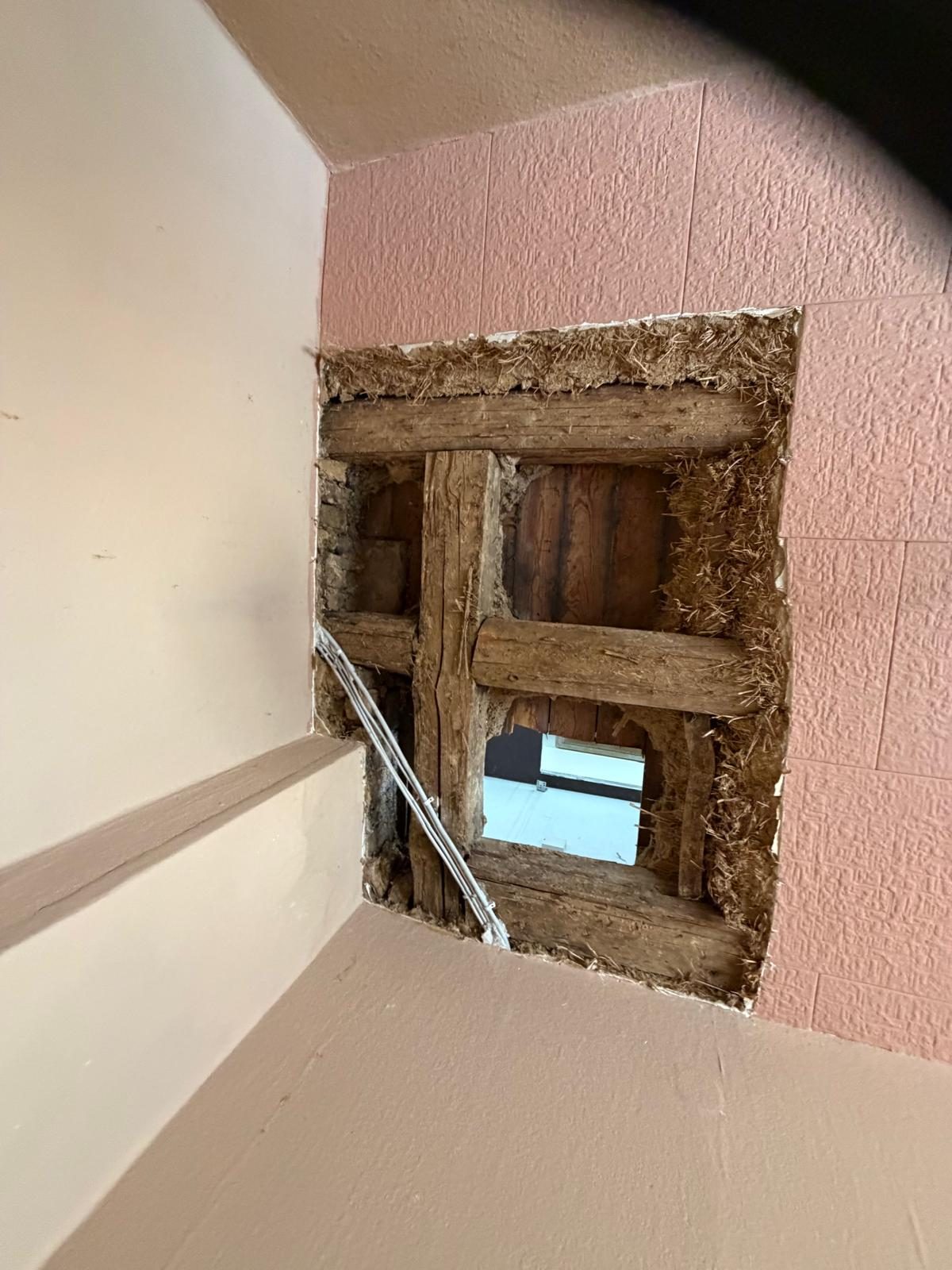 Geöffnete Holz-Lehmdecke nach Wasserschaden mit entfernter Lehmfüllung und sichtbarer Bauteilöffnung zur oberen Wohnung.