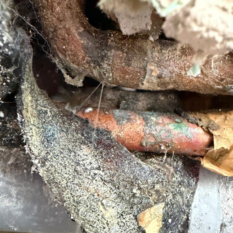 Wasser spritzt aus einer undichten Kupferleitung.