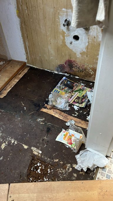 wasserschaden-kueche-bodenaufbau-beschaedigt Beschädigter Küchenboden nach Wasserschaden mit Feuchtigkeit an der Wand